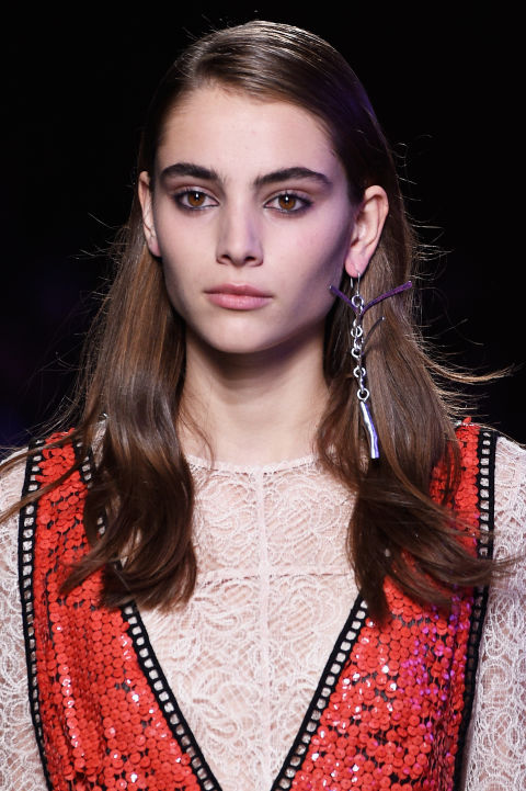 Inspired by 90s grunge, makeup artist Lucia Pieroni for MAC gave girls radiant skin against a "worn in for days" eye makeup look, with kohl liner applied on the top and bottom waterlines of the eyes. The hair was side parted with flat roots and a glossy texture.